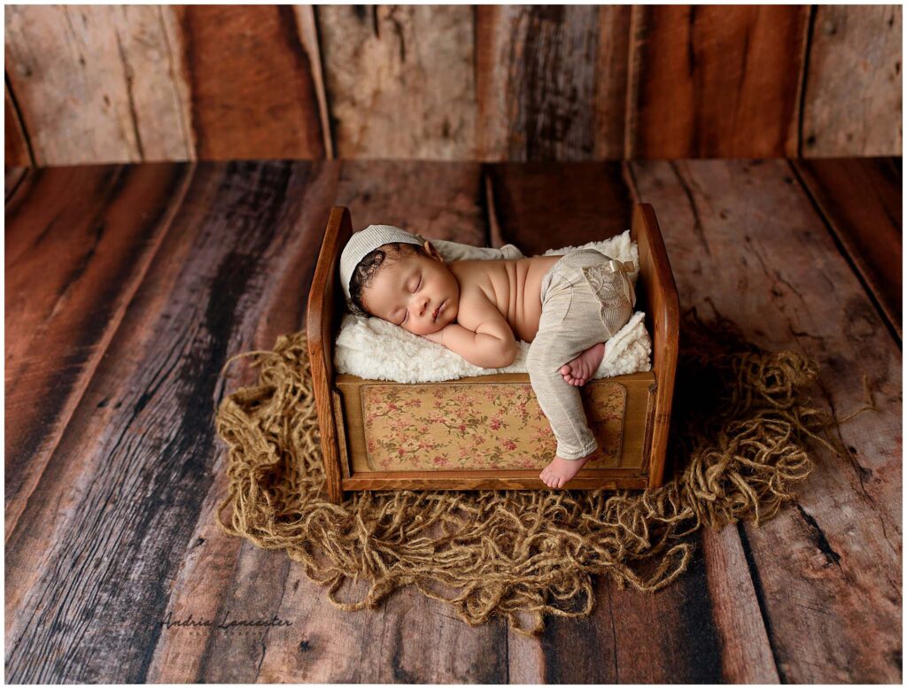Brooklyn newborn photography session newborn posed with feet hanging off bed prop