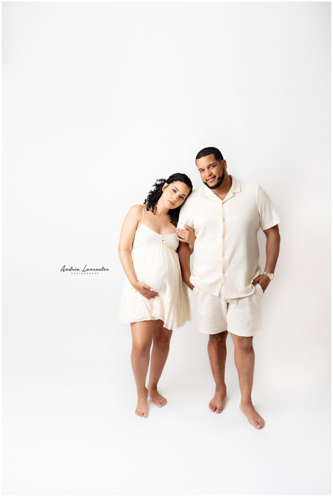 couple in studio maternity session off white outfits