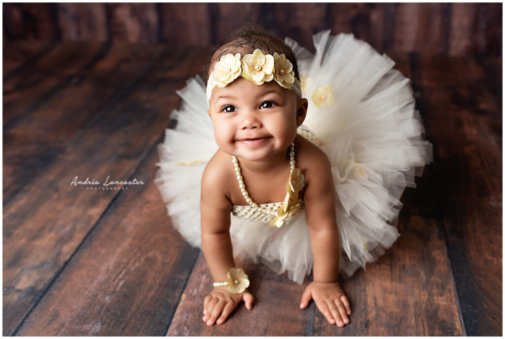 6 month old wearing tutu outfit with flowers looking up