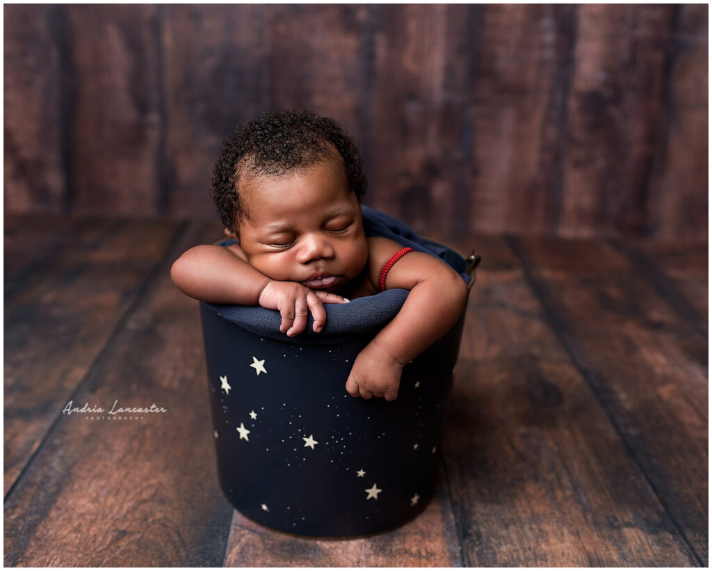 newborn boy in bucket with stars
