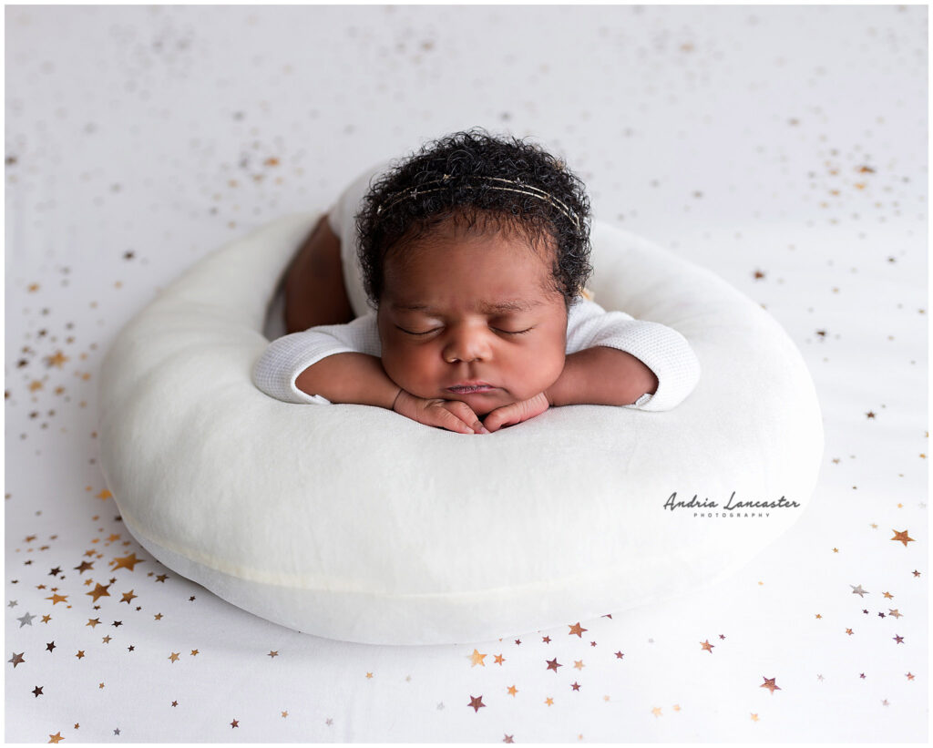 newborn girl on star backdrop and moon pillow