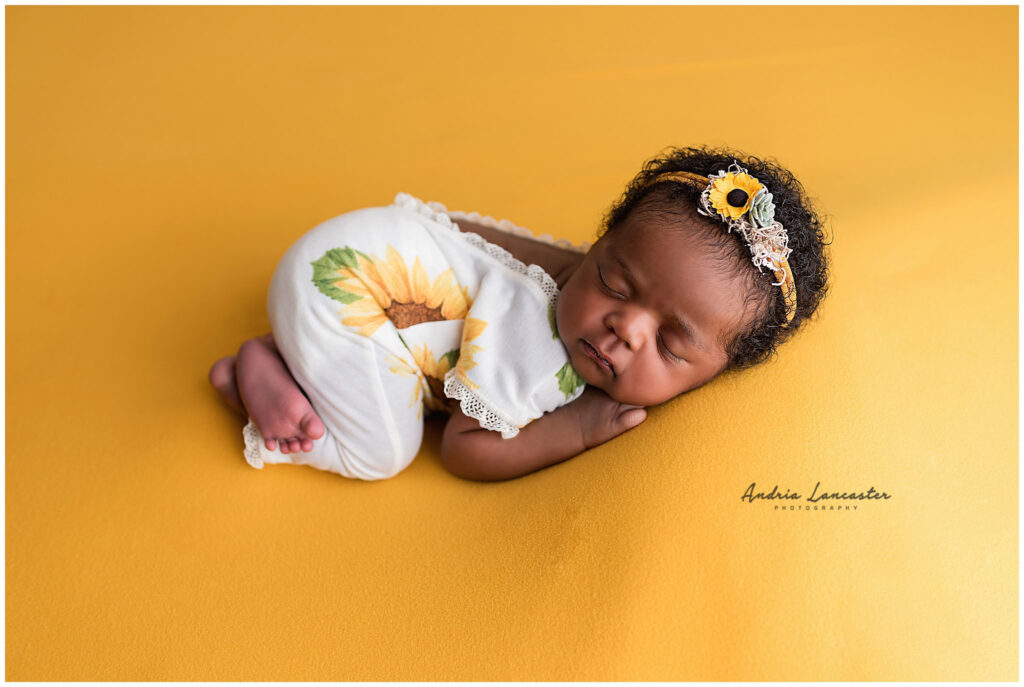 newborn girl in sunflower outfit and headband