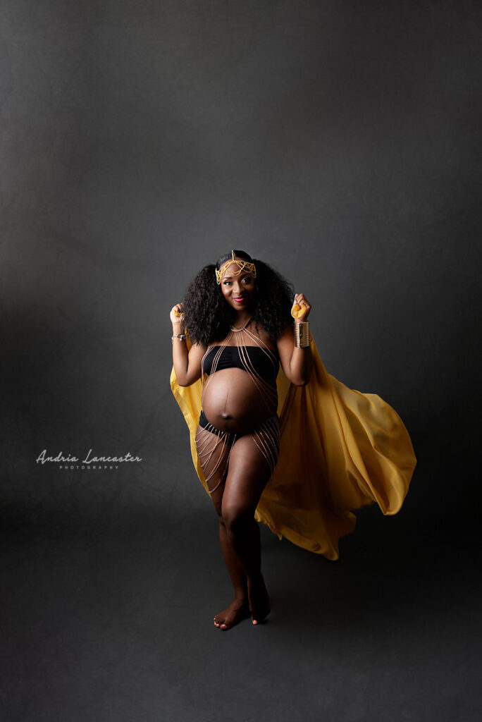 Maternity portrait with woman holding fabric in background
