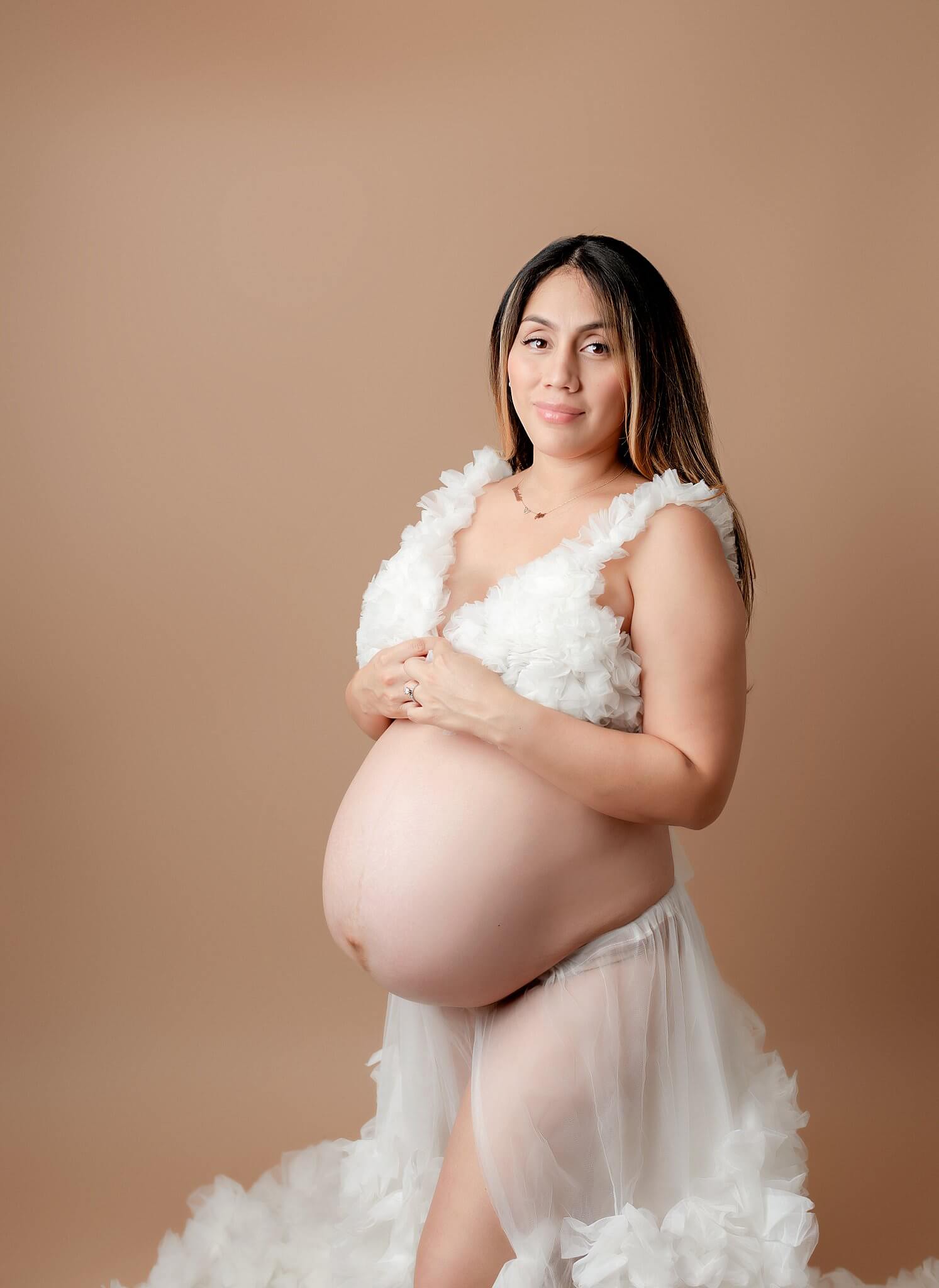 Maternity photos with mom wearing white two piece outfit.