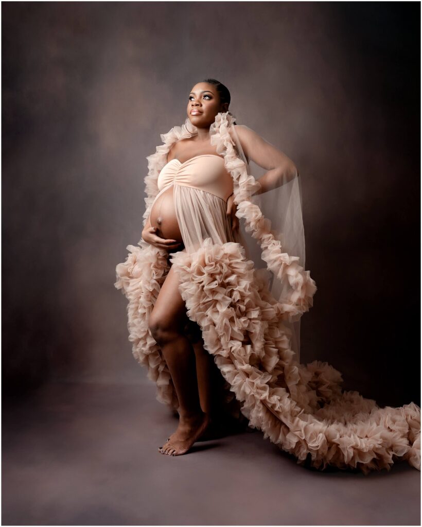 Pregnant woman embracing the beauty of motherhood in a cozy studio.