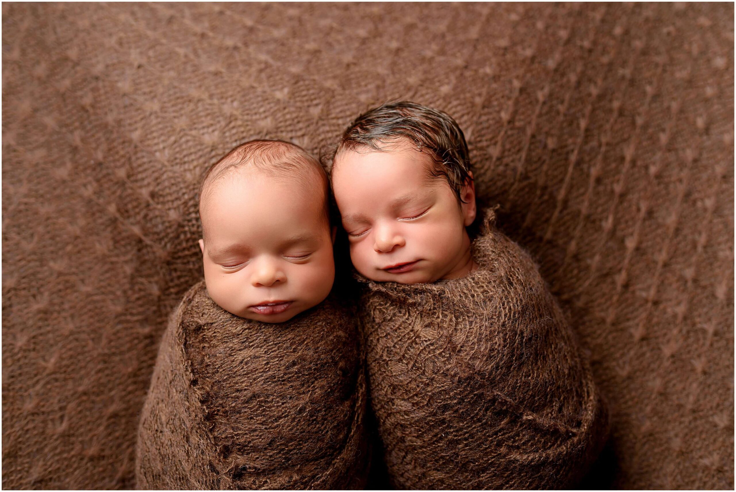 A close up photo of twins at their newborn photo session highlighting their delicate features as they sleep